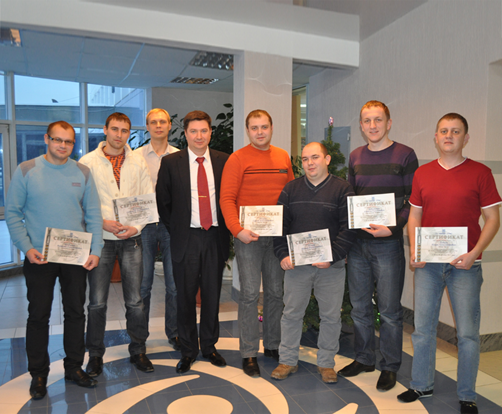 Group of trainees holding up their artificial lift training certificates